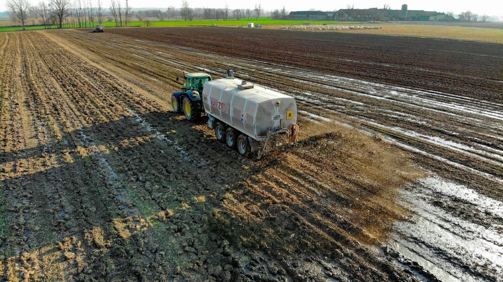 The difference between compost and soil- tractor spreading inorganic fertilizer